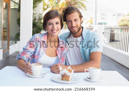 Happy couple enjoying coffee together outside at the coffee shop