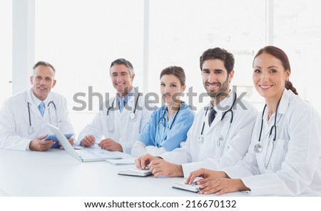 Doctors smiling at the camera as they all sit