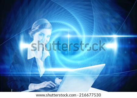 Redhead businesswoman using her laptop against blue technology design with tunnel