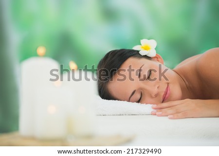 Beautiful brunette relaxing on massage table at a luxury spa
