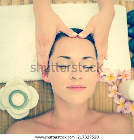 Smiling brunette enjoying a head massage in the health spa