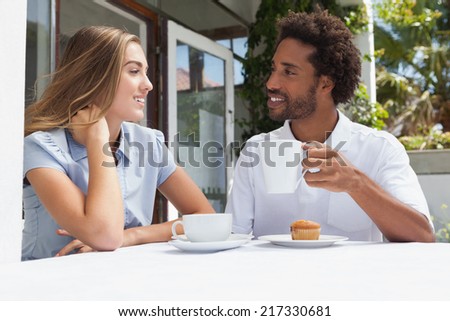 Happy couple having coffee together outside at the coffee shop