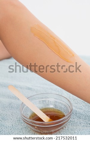 Close up side view of female leg with hot wax at spa center