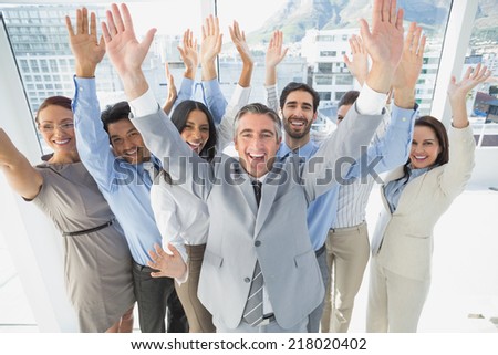 Cheering workers with raised arms in the office