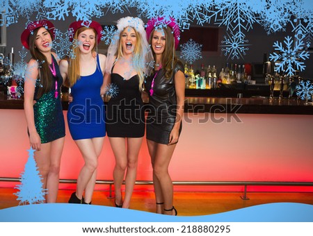 Laughing friends having a hen party against snow flake frame in blue