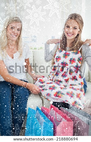 Composite image of Girls trying out new clothes as they look at the camera with snowflakes on silver