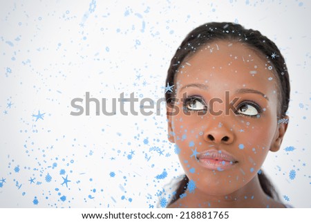 Close up of womans face looking upwards diagonally on white background against snow falling