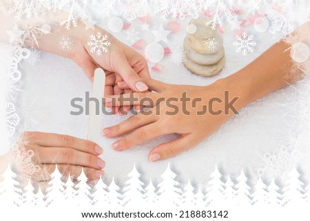 Nail technician filing customers nails against fir tree forest and snowflakes