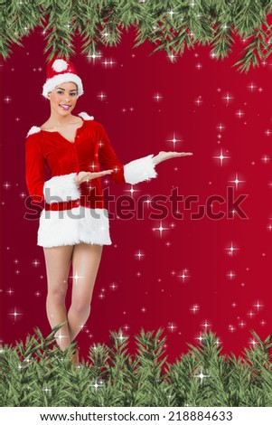 Composite image of a Pretty santa girl smiling at camera and presenting against twinkling stars