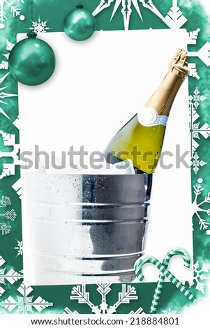 Christmas frame against bottle of champagne chilling in ice bucket