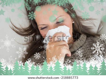 Sick woman lying on sofa and blowing nose against snowflakes and fir trees in green