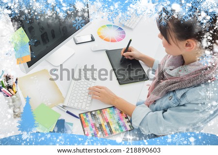 Artist drawing something on graphic tablet at office against snow