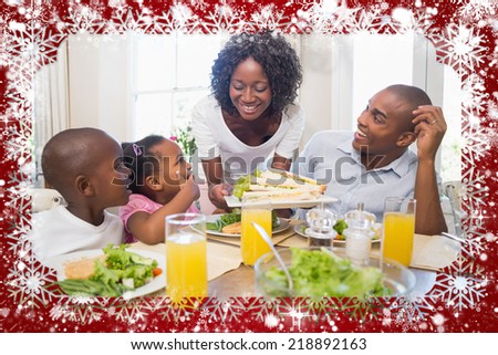 Happy family enjoying a healthy meal together against snow