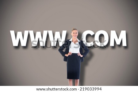 Businesswoman standing with hands on hips against grey background with vignette