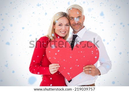 Handsome man getting a heart card form wife against snow falling