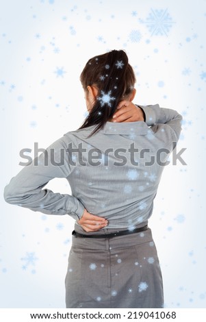 Portrait of the painful back of a businesswoman against snow falling
