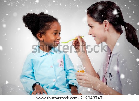 Composite image of adorable little girl taking medicine against snow falling