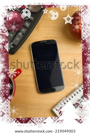 Christmas themed frame against overhead of smartphone with calculator
