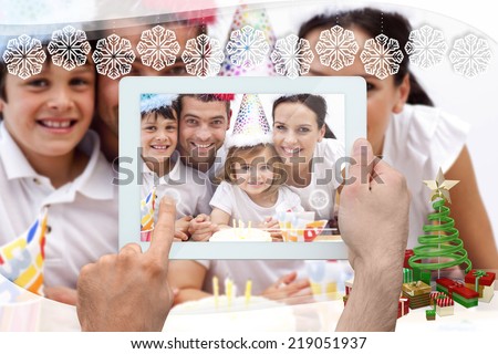 Hand holding tablet pc against snowflake frame