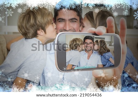 Hand holding smartphone showing photo against snow flake frame in blue