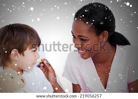 Composite image of smiling doctor taking childs temperature against snow