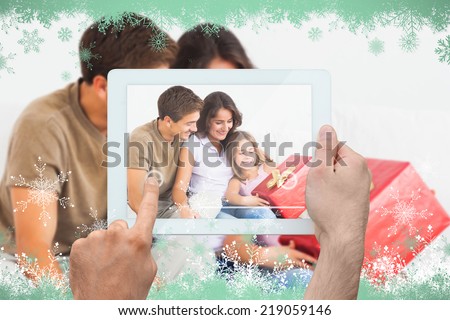 Hand holding tablet pc against snow flake frame in green