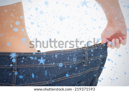 Close up of a woman waist in a too big pants against snow falling