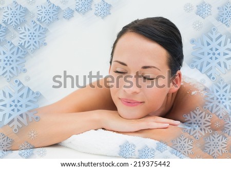 Peaceful brunette lying with salt scrub on back against snowflake frame