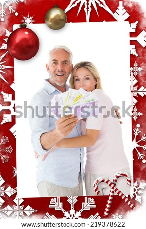 Happy couple flashing their cash against christmas themed page