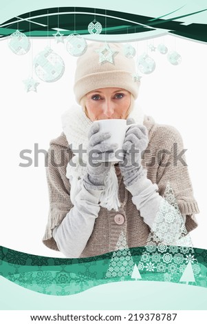 Mature woman in winter clothes holding mug against christmas frame