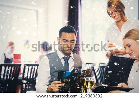 Composite image of two business people ordering dinner against snow falling