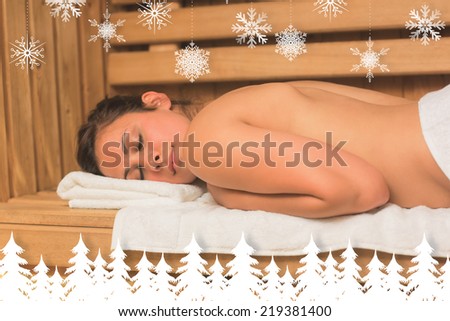 Calm brunette lying down in a sauna against fir tree forest and snowflakes