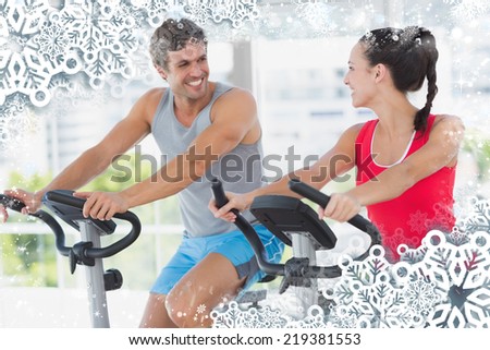 Smiling couple working out at spinning class against snow