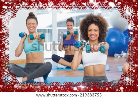 Portrait of a fit class lifting dumbbell weights against snow