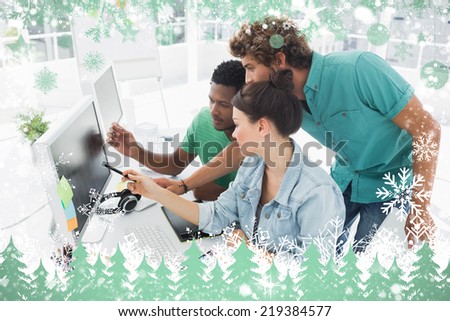 Three artists working on computer at office against snow