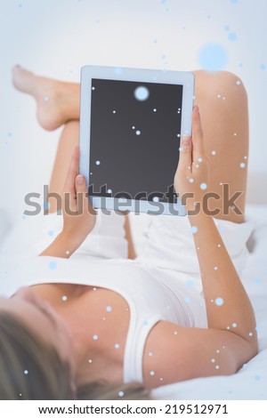 Calm woman touching her tablet pc against snow falling