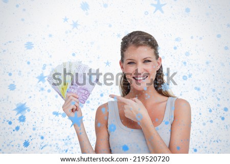 Woman pointing at bank notes against snow falling