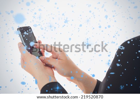 Composite image of woman using smart phone against snow falling