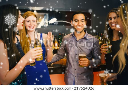 Composite image of Happy friends holding beers against snow falling