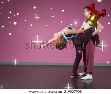 Cool break dancing couple dancing together against golden bell with red ribbon