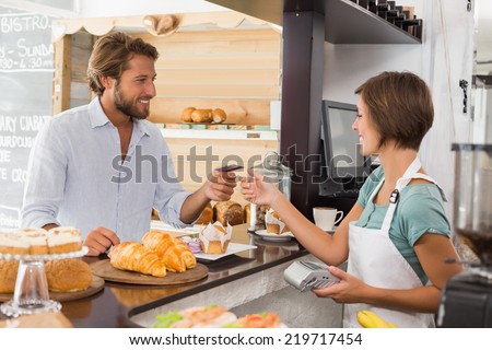 Pretty waitress serving happy customer at the coffee shop