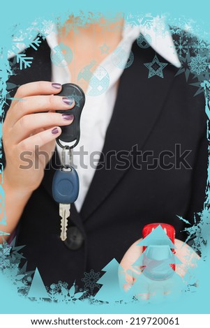 Composite image of Woman holding key and small car in her palm in a christmas frame