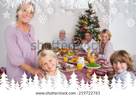 Grandmother and granddaughter standing beside the dinner table against fir tree forest and snowflakes