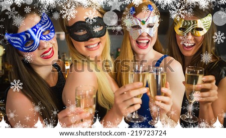 Composite image of a Smiling friends holding champagne glasses wearing masks against snowflakes