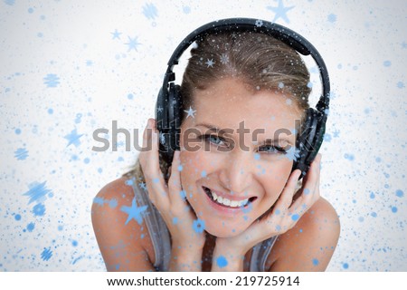 Close up of a happy woman listening to music against snow falling