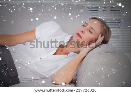 Composite image of businesswoman sleeping on couch against snow