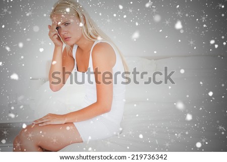 Composite image of cute woman having a headache against snow falling