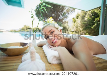 Portrait of a beautiful young woman lying on massage table at spa center