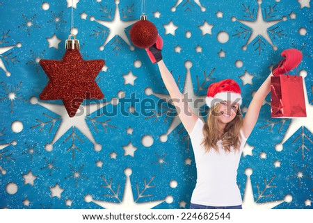 Festive blonde with boxing gloves and shopping bag against snowflake wallpaper pattern
