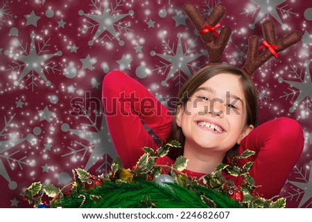 Festive little girl wearing antlers against snowflake wallpaper pattern